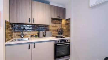 A modern kitchen with wooden cabinets, a stainless steel sink, and a built-in oven.