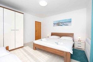 Une chambre à coucher avec un lit en bois, une armoire, une table de chevet et un tableau accroché au mur.