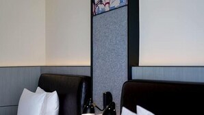 Une chambre d’hôtel avec deux lits, une table de chevet avec une lampe et un panneau décoratif au mur.