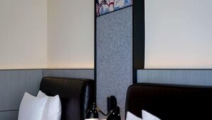A hotel room with two beds, a nightstand with a lamp, and a decorative wall panel. - Moxy Ningbo Old Bund (Ningbo)