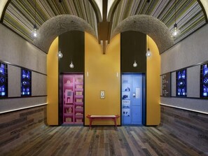 A hallway with a bench, two doors, and a patterned ceiling. - Moxy Ningbo Old Bund (Ningbo)