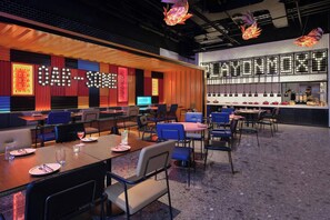 Een restaurant met een bar, zitplaatsen en een toonbank met etenswaren.