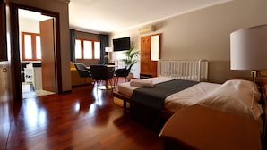 A hotel room with a bed, a desk, a chair, a TV, and a window. - Le Cinèma (Formia)
