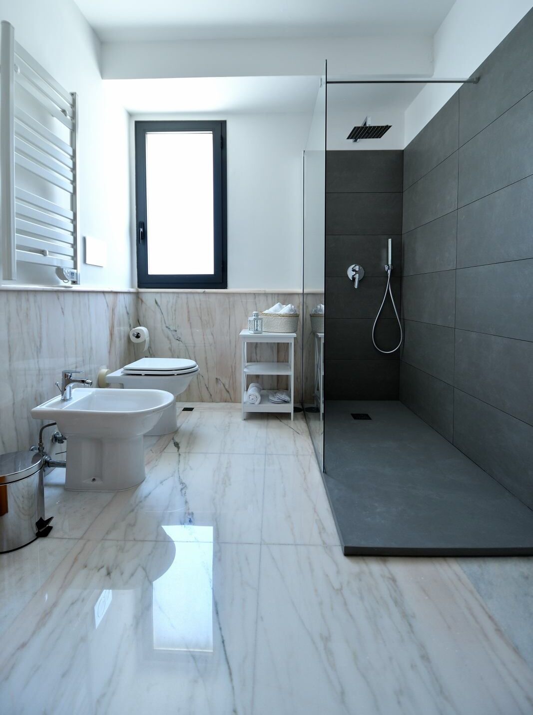 A modern bathroom with a bidet, toilet, and walk-in shower.