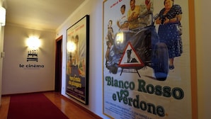 A hallway with a cinema sign and a movie poster for 'Bianco Rosso e Verdone'. - Le Cinèma (Formia)