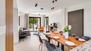A modern dining area with a wooden table set for four, surrounded by black chairs.