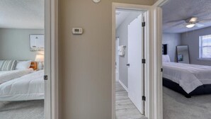 Ein Schlafzimmer mit zwei Betten, einem Deckenventilator und einem Thermostat.