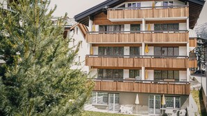 Un edifici d'àmbit elevat amb balcons de fusta i grans finestres.