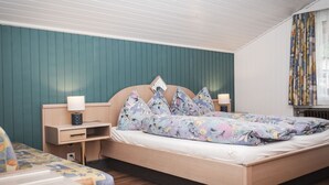 A bedroom with a bed, nightstands, and a dresser.