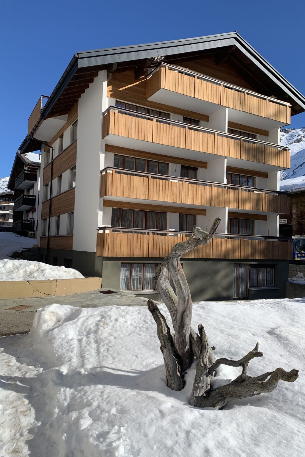A multi-story hotel with wooden paneling and balconies, surrounded by snow.