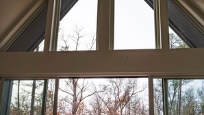 Una habitación amplia con un gran ventanal corredero que da a un espacio exterior.