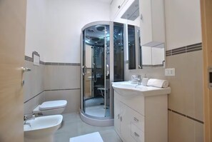 Regadera, secadora de cabello, bidet, toallas 