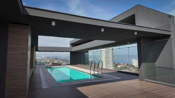Una piscina en la azotea con vistas a un paisaje urbano.