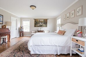 A bedroom with a large bed, a desk, a chair, a lamp, and a painting on the wall. - The Franklin Farmhouse of Franklin, TN (Franklin)