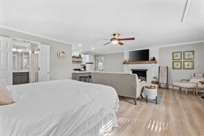 Ein Schlafzimmer mit einem großen Bett, einem Deckenventilator und einem Kamin.