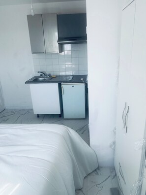 A compact kitchen with a refrigerator, sink, and a microwave. - Cozy Studio Retreat in Mitcham (Mitcham)