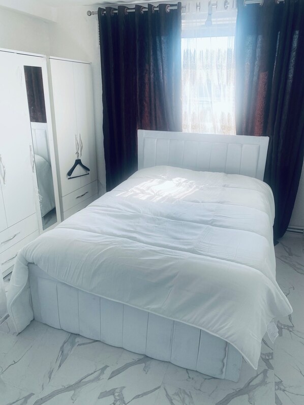 A bedroom with a large bed, a wardrobe, and a mirror. - Cozy Studio Retreat in Mitcham (Mitcham)