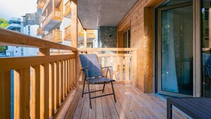 A wooden balcony with a chair, stone wall, and large windows. - Wifi, 80m from ski slopes, balcony, tv, ski locker, 37-39m², Vars (Vars)