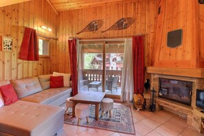 A cozy cabin interior with a sofa, a small table, and a fireplace.