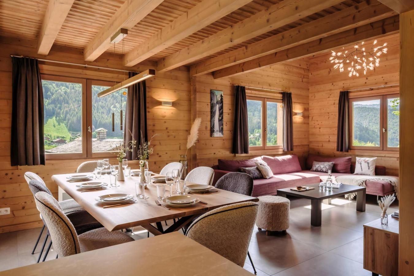L’intérieur d’un chalet en bois comprend un coin repas, un canapé et offre une vue sur l’extérieur.