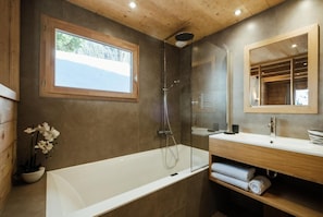 Ein modernes Badezimmer mit Badewanne, Dusche und Waschtisch.