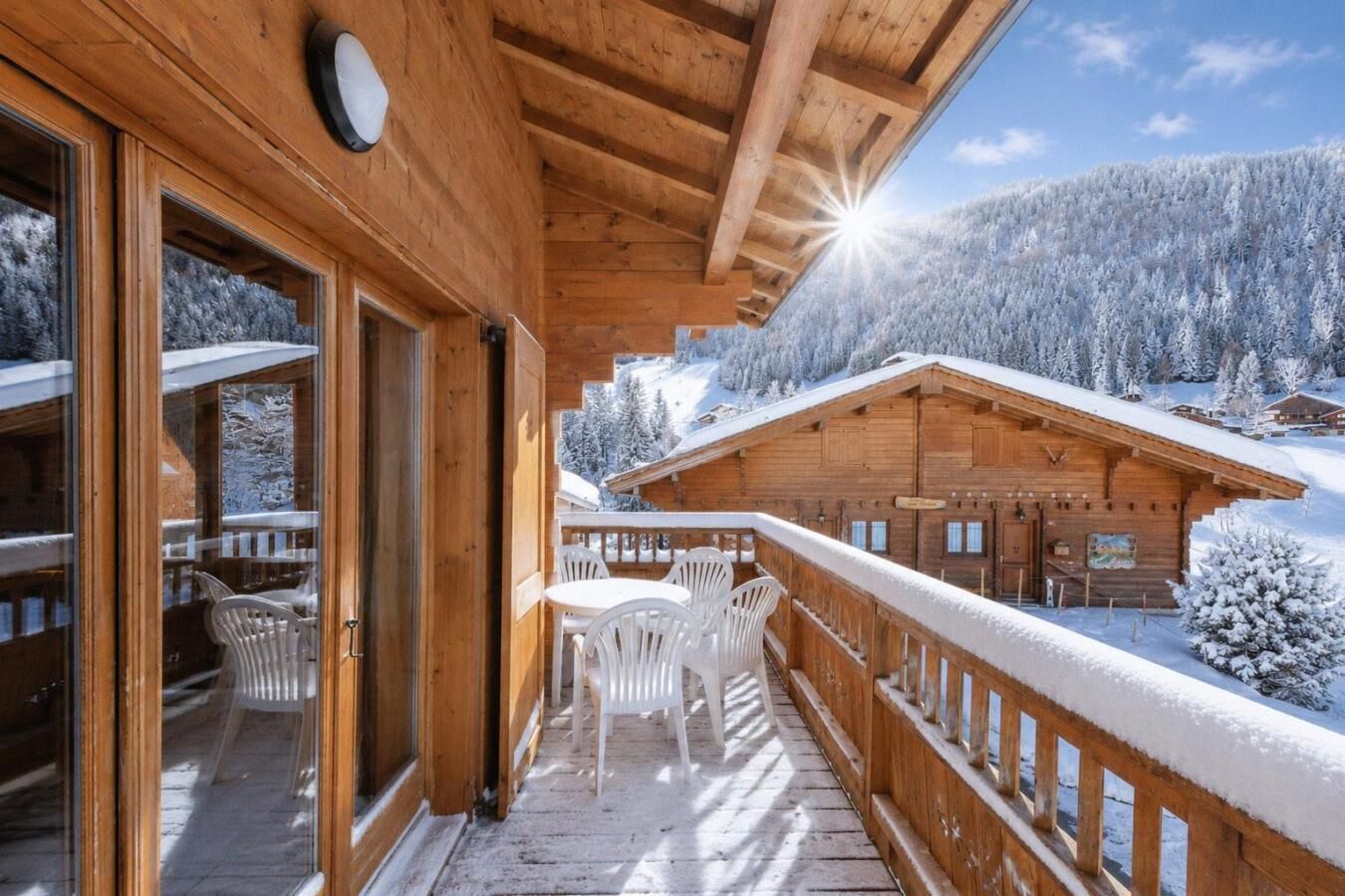 Un balcon en bois offrant une vue sur une montagne enneigée.