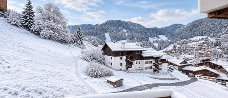 A snow-covered mountain village with wooden buildings and a clear sky.