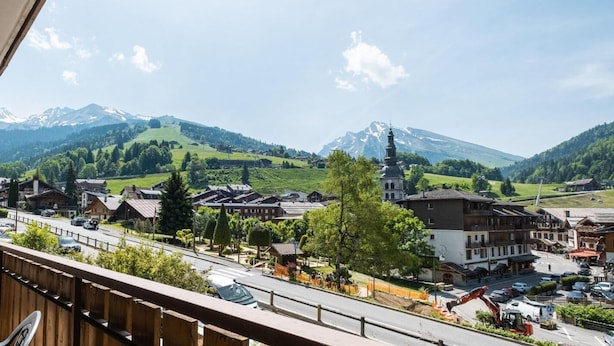 A town with buildings, a road, and a mountain in the background.