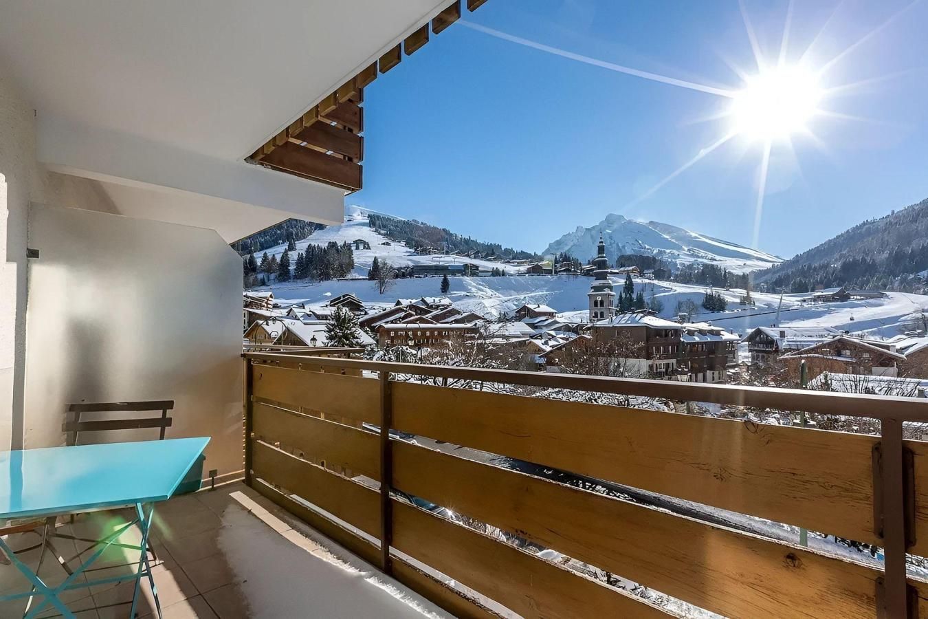 Een balkon met uitzicht op een besneeuwd berglandschap.
