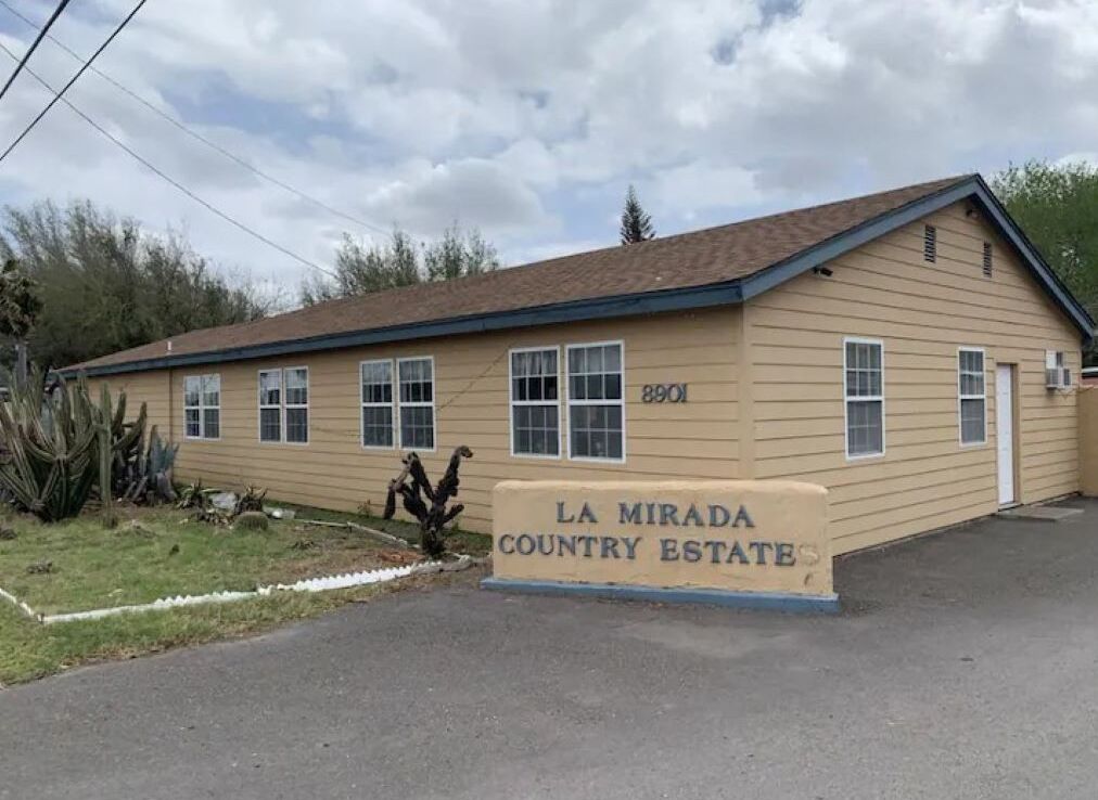 A single-story building with a beige exterior and a brown roof, labeled "La Mirada Country Estate."