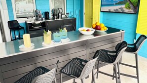 Une cuisine dotée d’un îlot central, de tabourets de bar et d’une table à manger.