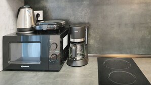 A kitchenette with a microwave, coffee maker, and kettle. - Apart in the Heart Of Athens (Athina)