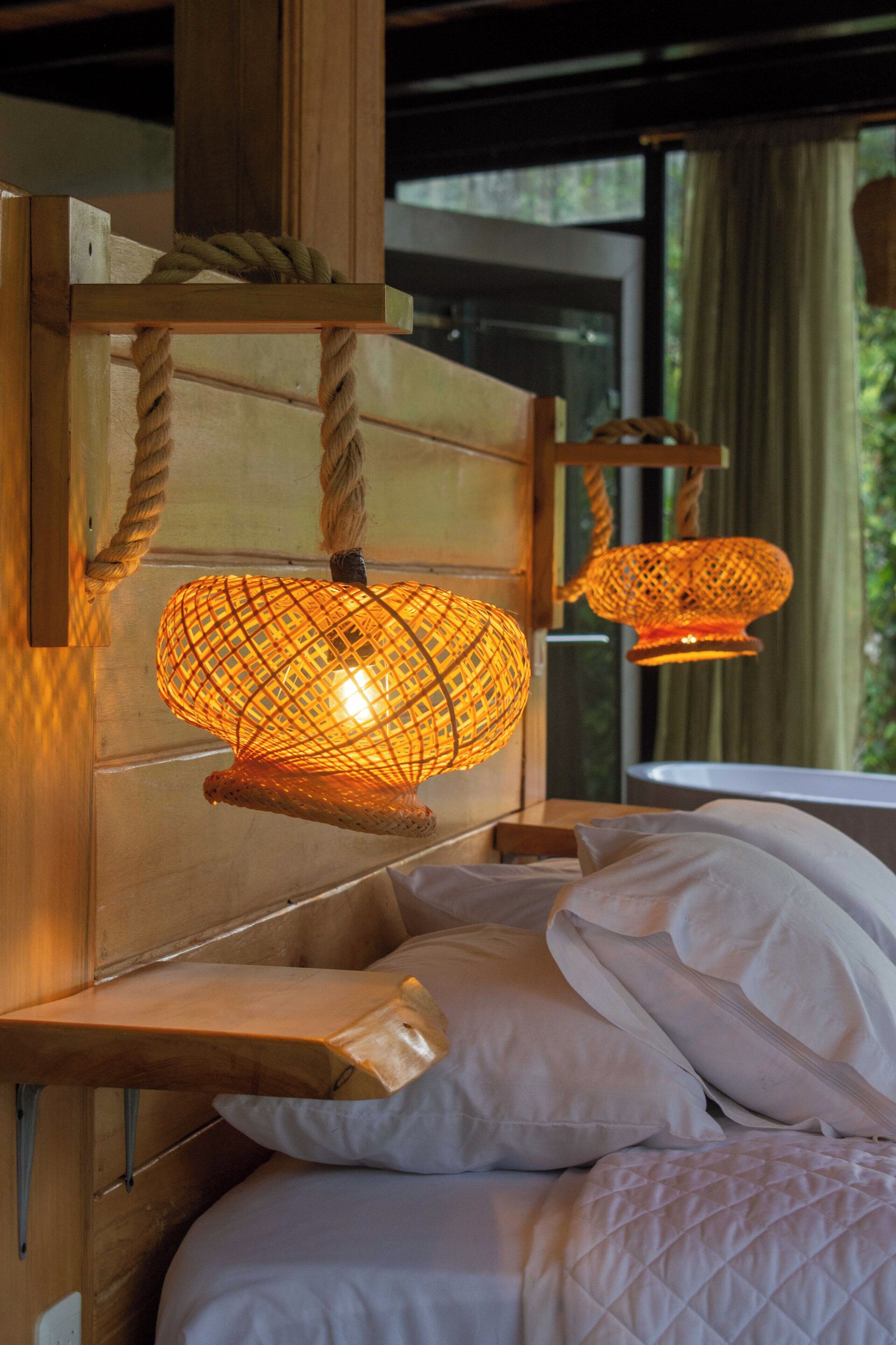 Una cama con ropa blanca y cabecera de madera.