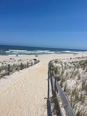 A sandy beach path leading to the ocean with a wooden fence on one side. - Bernie Beach House And Bungalow  (Lavallette)