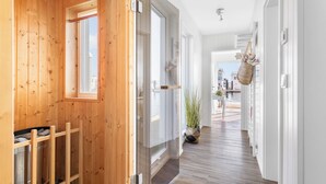 A wooden interior hallway with a view to an outdoor balcony.