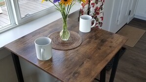 Ein Holztisch mit einer Blumenvase und zwei weißen Tassen.