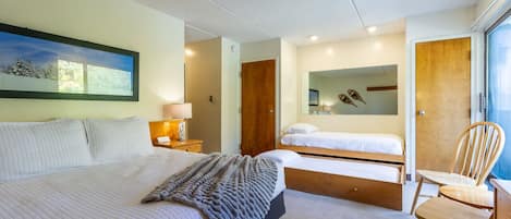 Un dormitorio moderno con una cama grande, una cama más pequeña, un escritorio y una silla.