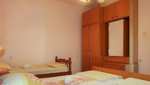Un dormitorio con dos camas individuales, un armario de madera y un espejo.