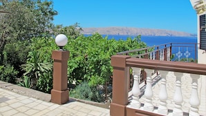 Un balcón con vistas al mar y a las montañas.
