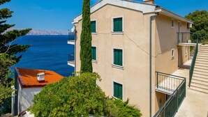 Ein Gebäude mit Balkon, Treppe und Meerblick.