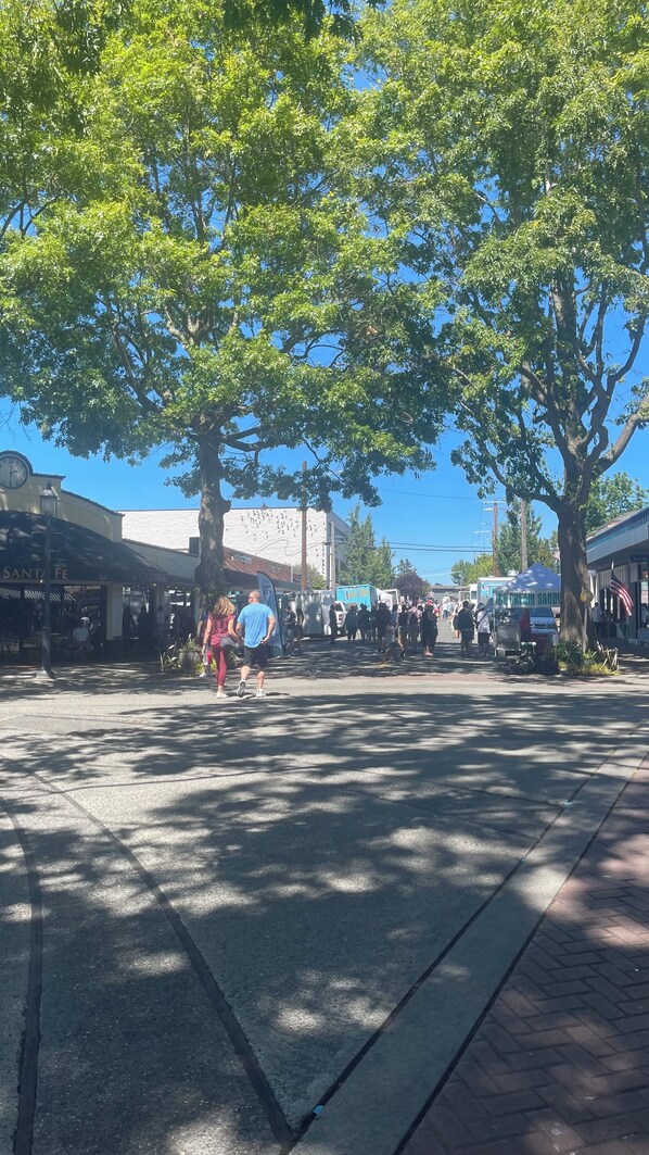 A busy street scene with pedestrians, trees, and storefronts. - Apartment at the Bowl (Edmonds)