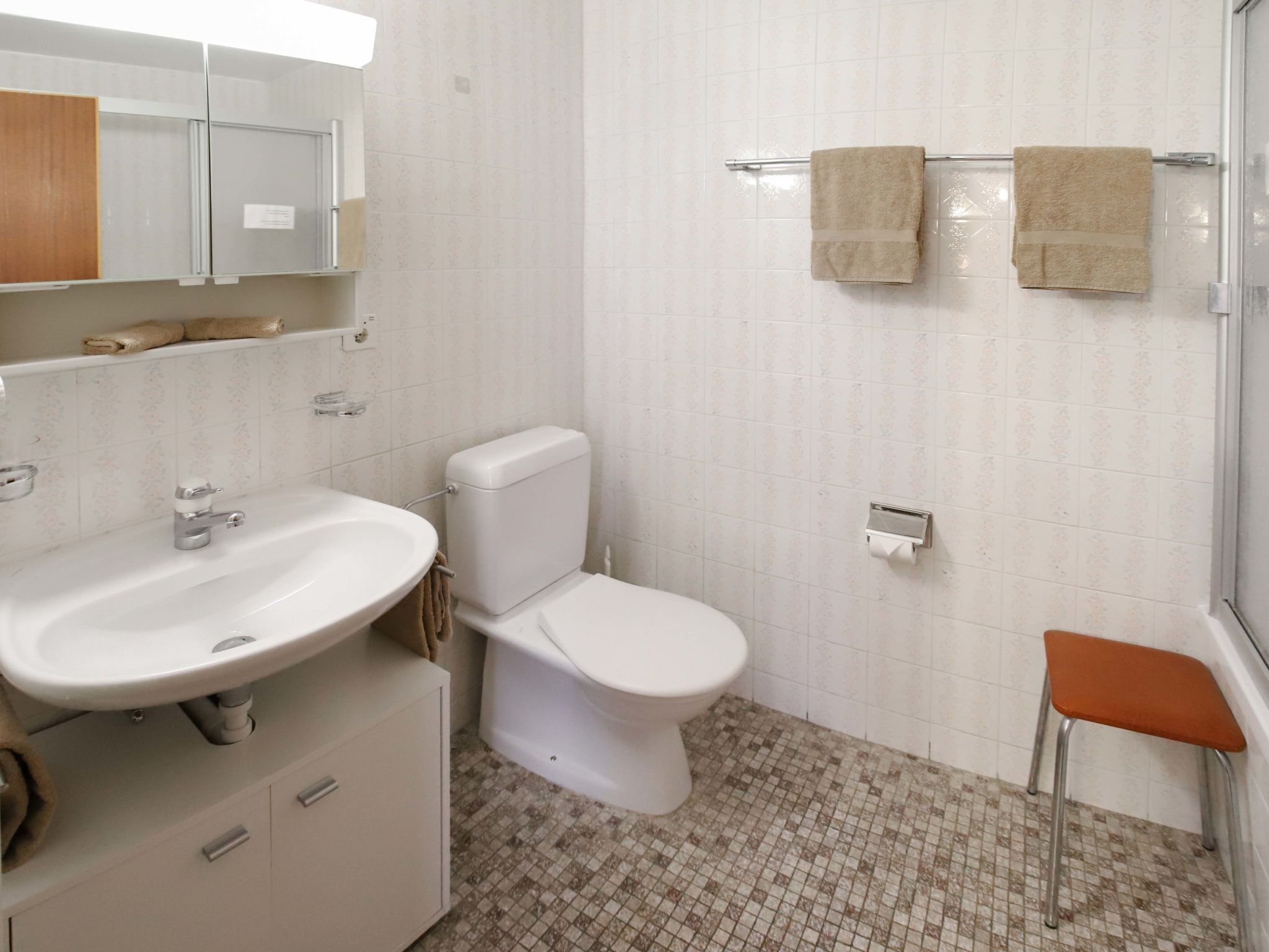 Ein Badezimmer mit Waschbecken, Toilette und Duschbereich.