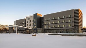Un hotel moderno con fachada de piedra y varios pisos.