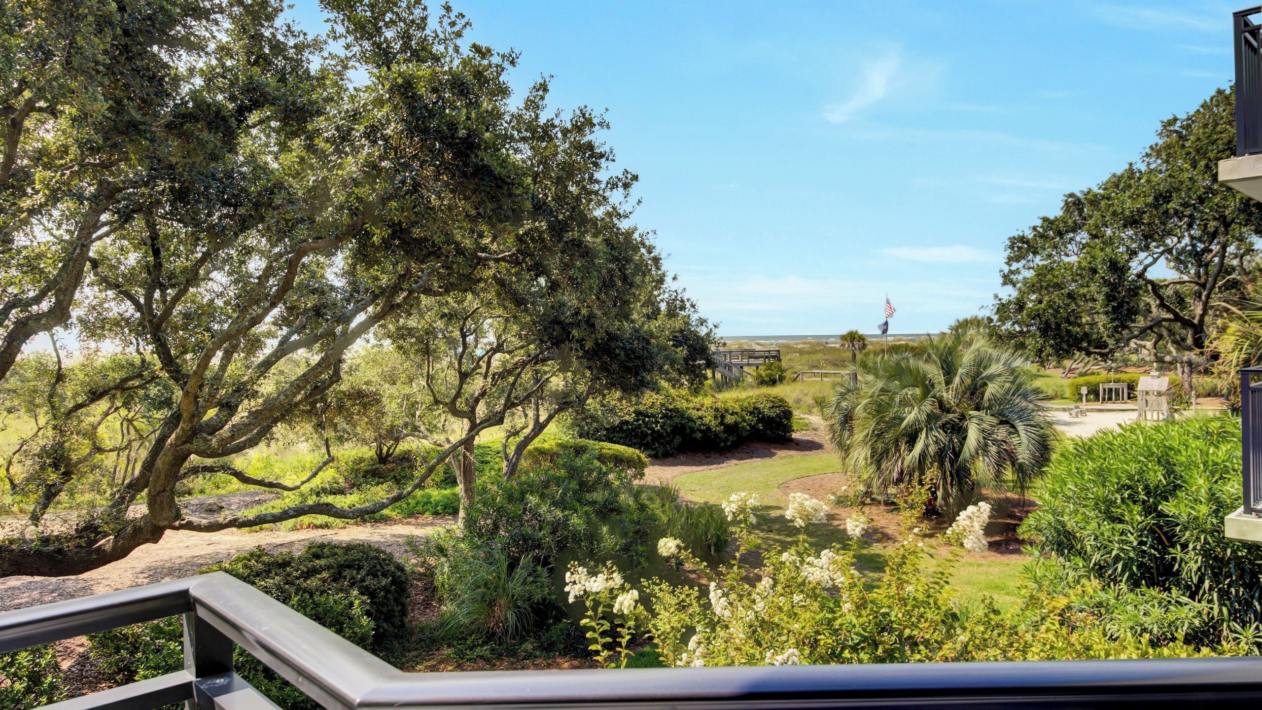 Un jardin luxuriant, avec de grands arbres et un pont en bois.