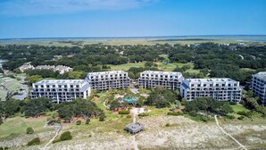 A large hotel complex with multiple buildings, a central pool area, and surrounding greenery. - 123d Shipwatch by Avantstay Beach Access + Pool (Isle of Palms)
