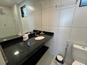 A modern bathroom with a black granite countertop, a white sink, and a toilet. - Smart Stay Apto 405 Mandi Hospitalidade (Maceió)
