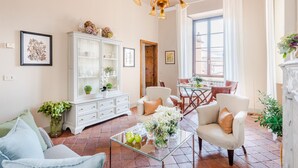 Un salon spacieux avec un meuble blanc, une table basse en verre et des sièges confortables.