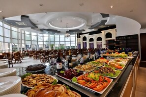 Disposição de buffet com diversos alimentos e um grande candelabro.