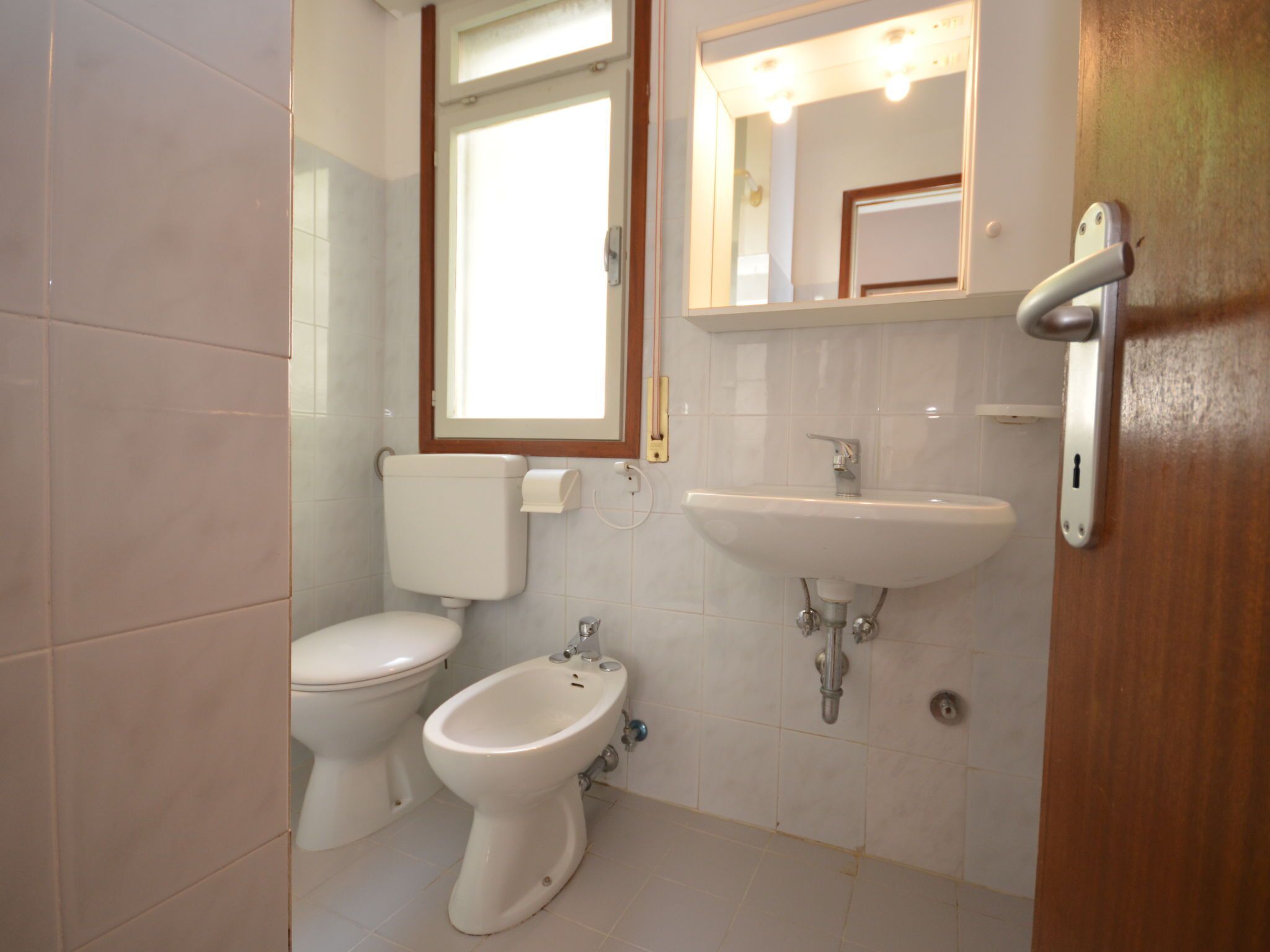 Un bagno con il water, bidet e lavandino.