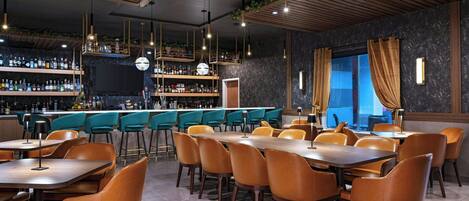 A restaurant with a bar area, wooden ceiling, and orange chairs.